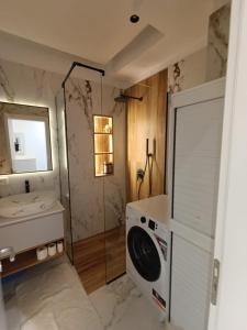 un bagno con lavatrice e lavandino di Genci's Apartaments a Vlorë Altre 76 foto