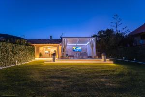 a house with a screen in a yard at night at Villa Vittorio in San Teodoro