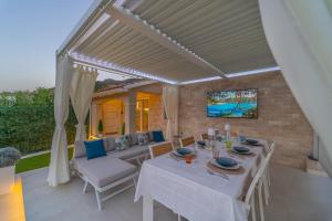 a dining room with a white table and chairs at Villa Vittorio in San Teodoro
