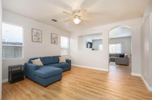 a living room with a blue couch and a ceiling fan at Central Bliss near parks & shops in Bakersfield