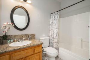 a bathroom with a sink and a toilet and a mirror at Central Bliss near parks & shops in Bakersfield +12 photos