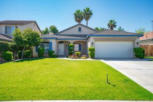 a house with a large yard with a garage at Central Bliss near parks & shops in Bakersfield
