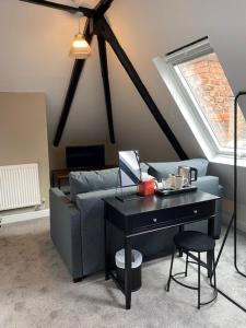 a living room with a couch and a table with a laptop at The Lowther Hotel in York