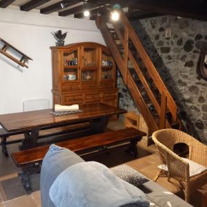 a dining room with a wooden table and a staircase at Maison de montagne, vallée d'Ossau in Bielle
