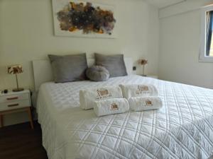 a bedroom with a white bed with towels on it at Casa da Eira Velha in Chaves