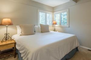 a bedroom with a large white bed with two lamps at Dollar Meadows Condo 1368 in Sun Valley +27 photos