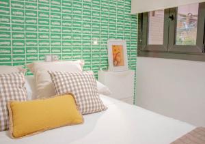 a bedroom with a white bed with a yellow pillow at Apartamento Boutique TOKIO in Garrucha