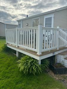 a white deck on a house in the grass at Stellas retreat in Cayton