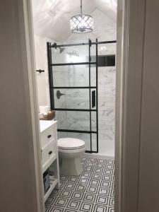 a bathroom with a white toilet and a shower at Jenny's Cottage WPool 3 Blocks from Downtown in Laurel +35 photos