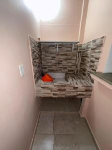 a bathroom with a brick wall and a red object at Casa frente al centro comercial in Montería