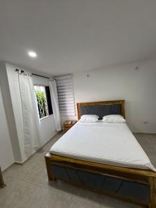 a bedroom with a large bed in a room at Casa frente al centro comercial in Montería