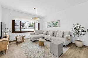 a white living room with a couch and a table at Casa Conchi Puerto del Carmen in Puerto del Carmen