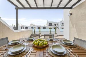 a table with plates and bowls of fruit on a patio at Casa Conchi Puerto del Carmen in Puerto del Carmen