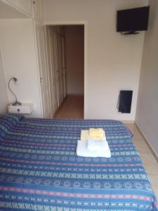 a bedroom with a bed with a blue and white bedspread at DEPARTAMENTo CÉNTRICO in Lobos +6 photos