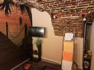 a room with a tv and a brick wall at Room nr 5 - La beci in Braşov