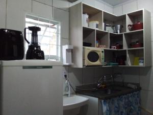 a small kitchen with a refrigerator and a microwave at Apto 10 preço acessível in Brasília +1 photo