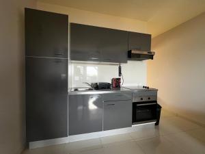 a kitchen with a stainless steel refrigerator and a stove at The little Heaven in Baie Nettle