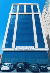 a tall building with cars parked in front of it at دار الرياض للشقق المخدومة بالخبر 2 in Al Khobar