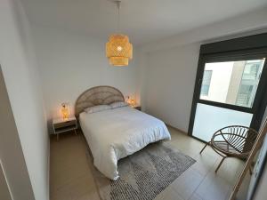 a white bedroom with a bed and a window at Apartamento Jardín de Cano - Preferente familias y mayores de 25 años in El Puerto de Santa María +19 photos