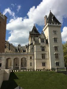 a large castle building with a grass yard at Hôtel Bosquet Pau Centre in Pau