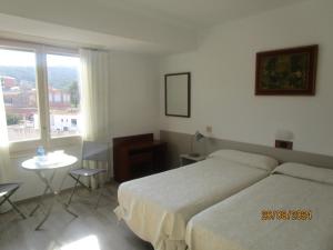 A bed or beds in a room at Hotel Apartaments Gesòria Porta Ferrada