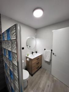 a bathroom with a toilet and a sink and a mirror at Apartamento La Avenida in Lanjarón +21 photos
