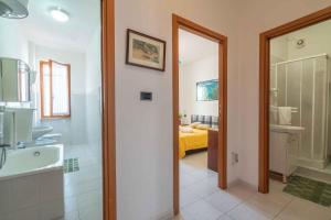a bathroom with a tub and a sink and a toilet at Holiday home in Alghero 44952 in Alghero