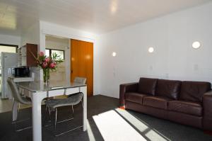 a living room with a couch and a table with flowers at Kawerau Thermal Motel in Kawerau