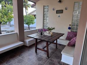 a porch with a wooden table and a bench at Beach House in Vasilikón