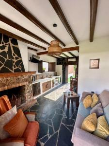 a living room with couches and a stone fireplace at Casa rural La Portilla in Aroche