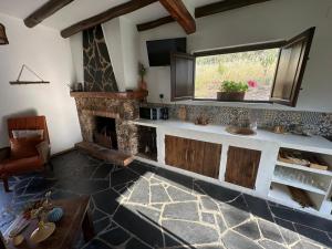 a kitchen with a stone fireplace and a sink at Casa rural La Portilla in Aroche