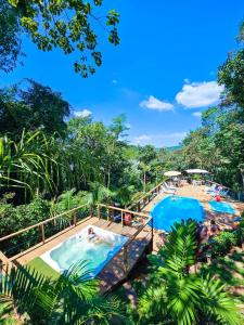 a pool at a resort with people swimming in it at Chalés Senhor Dos Trilhos in Mairiporã