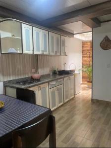 a kitchen with white cabinets and a table in it at Apartamento N2 completo independiente Montenegro in Montenegro
