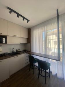 a kitchen with two chairs and a table and a window at Apartman Trijumf Lux in Vrnjačka Banja
