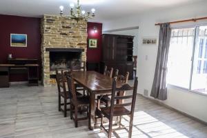 a dining room with a table and chairs and a fireplace at Casa Confite Baigorria in Paganini