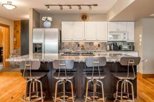 eine Küche mit einer Theke mit Barhockern in der Unterkunft Muskoka Lakeshore Cottage Bliss in Gravenhurst