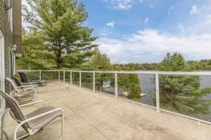 ein Balkon mit Stühlen und Blick aufs Wasser in der Unterkunft Muskoka Lakeshore Cottage Bliss in Gravenhurst