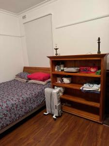 a bedroom with a bed and a book shelf at Ashburton big Room with shared bathroom 1 in Chadstone
