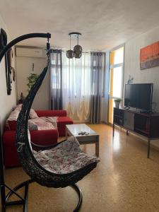 a living room with a swing chair in front of a tv at Apartamento maspalomas 3 hab stay in gran canaria in Maspalomas