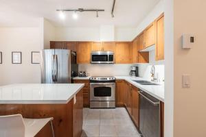 a kitchen with wooden cabinets and stainless steel appliances at Deer Run by Outpost Whistler in Whistler