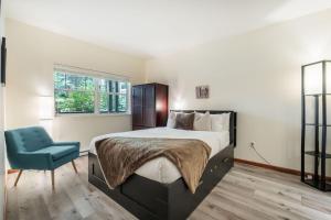 a bedroom with a bed and a blue chair at Deer Run by Outpost Whistler in Whistler