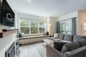 a living room with a couch and a tv at Deer Run by Outpost Whistler in Whistler