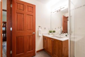 a bathroom with a sink and a mirror at Deer Run by Outpost Whistler in Whistler +32 photos