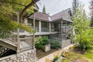an exterior view of a house with a stone wall at Deer Run by Outpost Whistler in Whistler