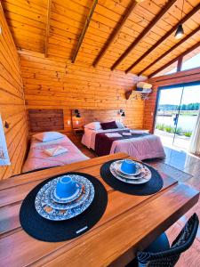 a room with two beds and a table with hats on it at Cabanas Colina Do Sol in Cambara do Sul
