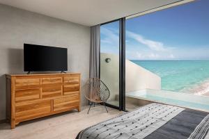 Un dormitorio con televisión y vista al mar. en Oceanview PH studio at Tankah Bay, en Tancah