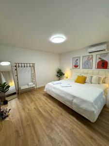 a bedroom with a large white bed and wooden floors at FILIN HOME with KING SIZE BED in Chişinău