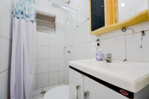 une salle de bain blanche avec un lavabo et une douche dans l'établissement Apartamento 2 completo, à Guarulhos