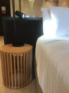 カジュアライナにあるCoastal Bliss Studio - Santai 224のベッドとランプ付きのテーブルがある寝室