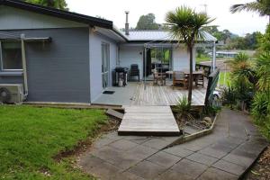 a porch with a wooden deck next to a house at Bobs Haven - Long Bay Coromandel in Coromandel Town